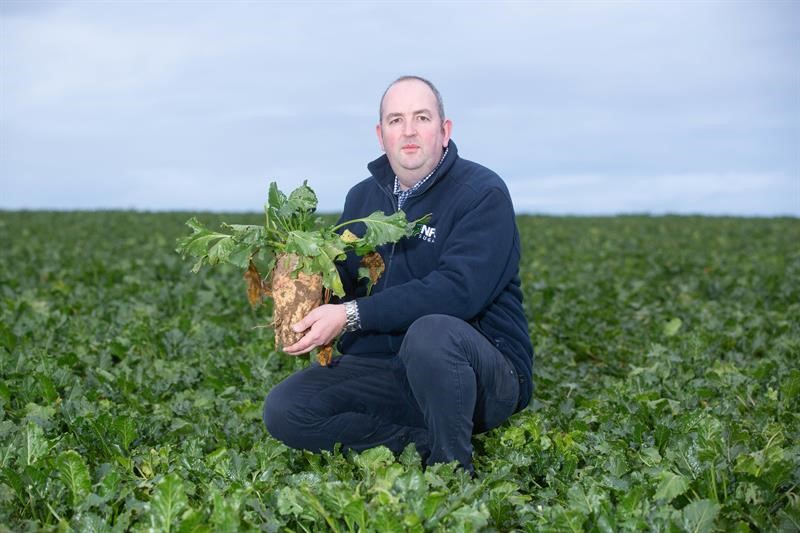 NFU Sugar board vice-chair Simon Smith holds some sugar beet in a field