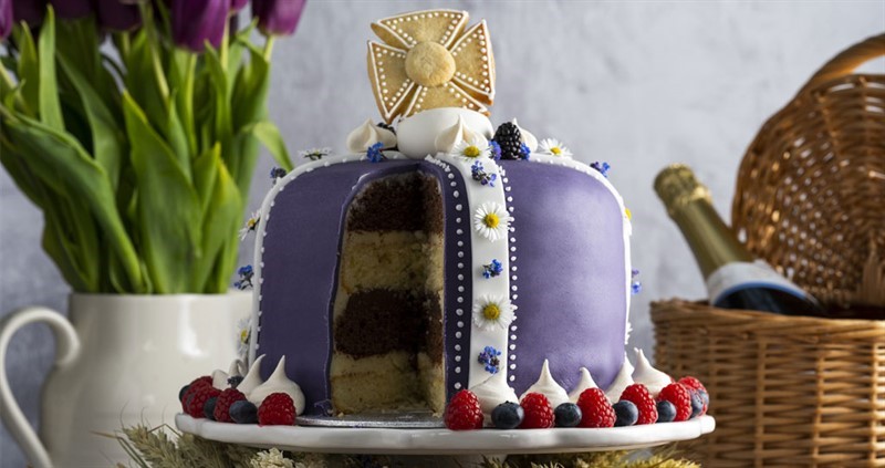 An image of the Jubilee crowning glory cake, with one slice taken out and on a cake stand.
