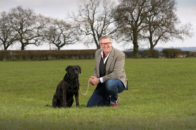 a picture of Graeme Hall and his black labrador