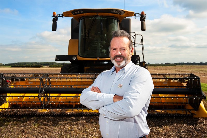 An image of NFU Environment Forum chair Richard Bramley in front of a combine harvester