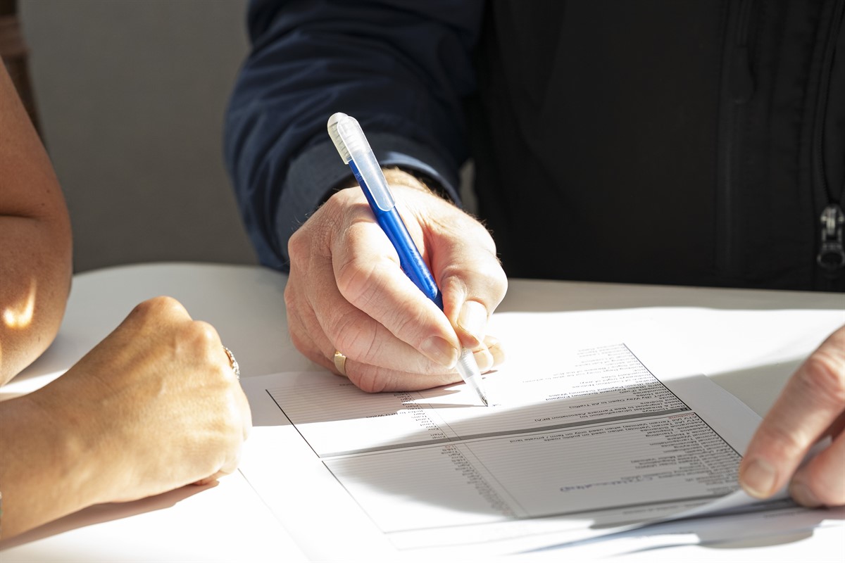 Two people sit going through a checklist