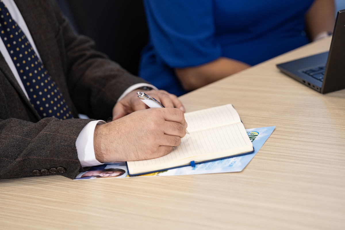 A man sits writing in a notebook