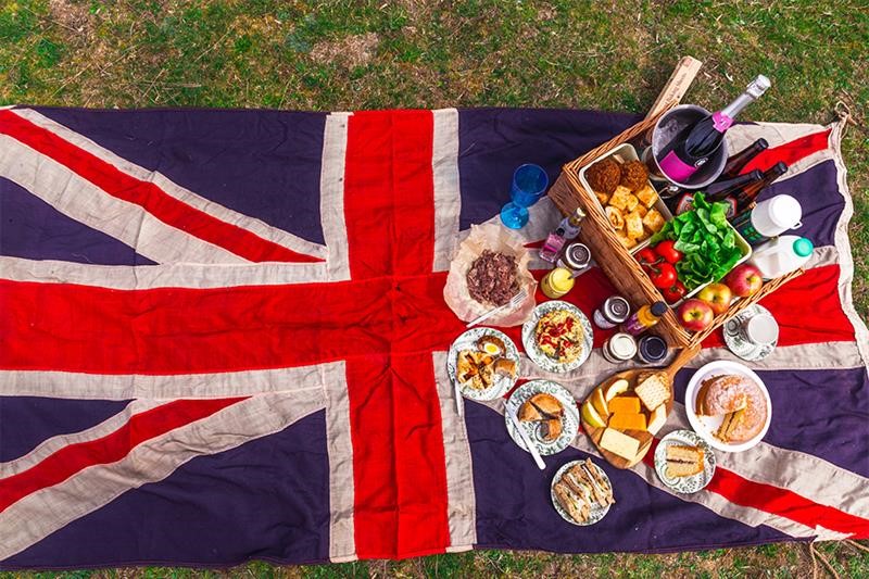 A photo of a food hamper on top of a british flag.