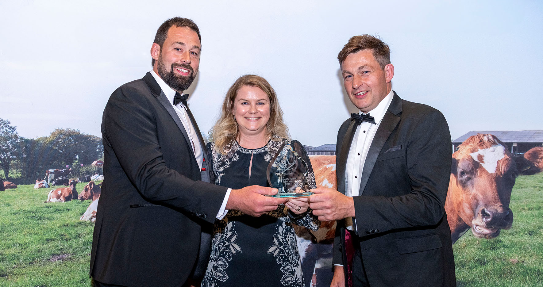 Three people holding an award