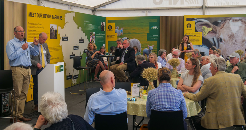 A crowd of people in a marquee listening to a speaker