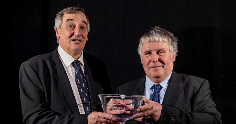 An image of Phil Smallwood collecting his award from Meurig Raymond