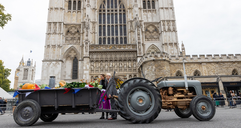 Peter Drinkwater stood with the tractor and trailer display outside Westminster Abbey