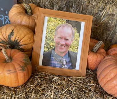 A framed photo of Michael Wilshaw in a pumpkin patch