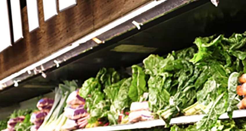 A photograph of vegetables on a supermarket shelf