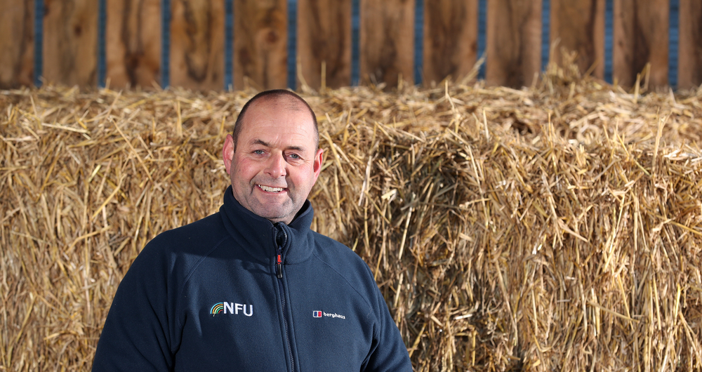 NFU dairy board chair Michael Oakes stood in front of hay