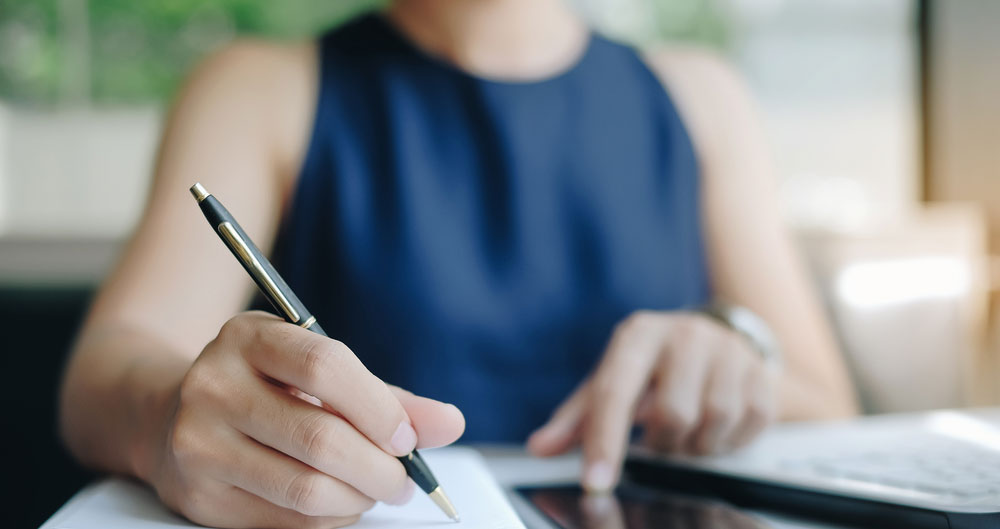 woman writing at desk