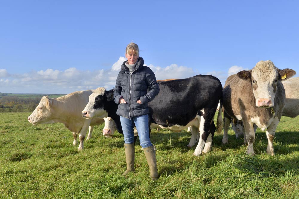 NFU President Minetter Batters standing in front of cows on her farm