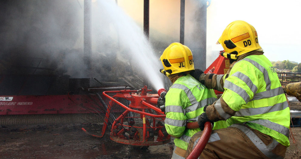 Firefighters hosing down a burning barn