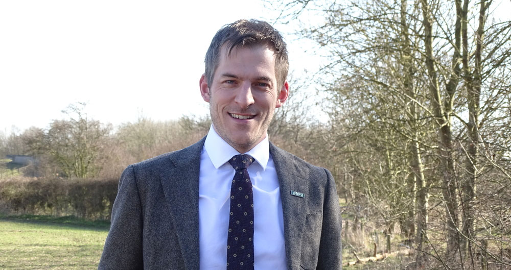 Adam Bedford standing in a field of arable crops